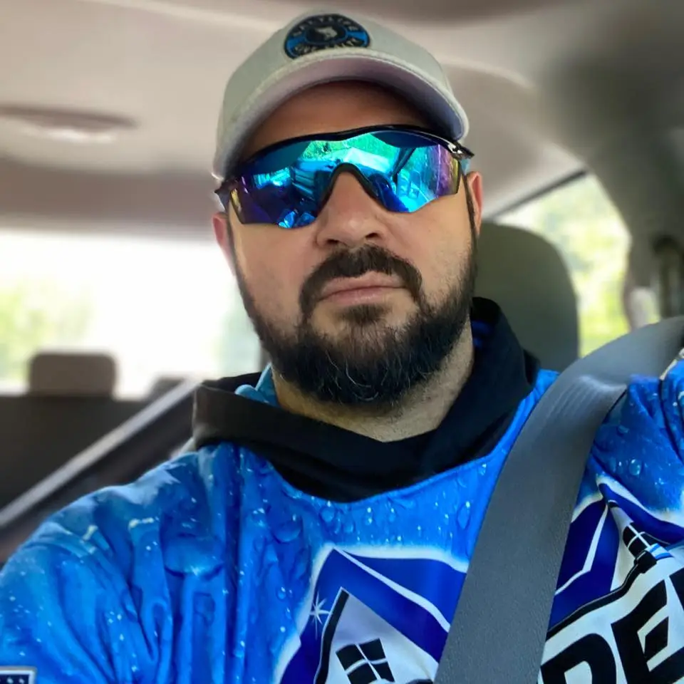 Blake Bowden Owner of Bowden Pro Wash sitting in his truck wearing blue sunglasses and his blue company uniform