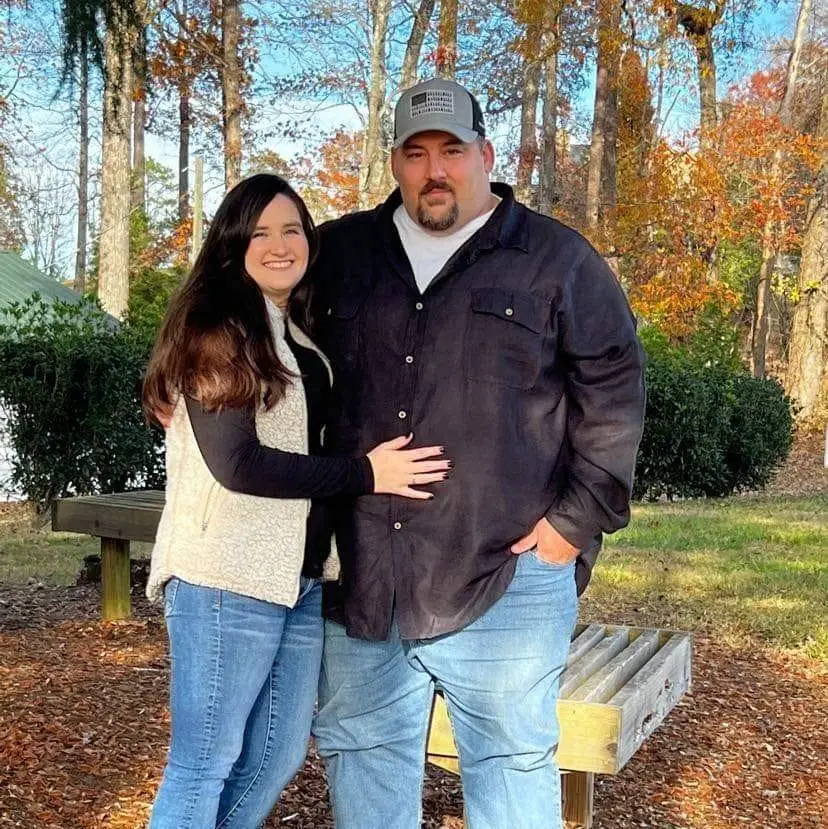 Nick Gilliland of Bill's Tree and Landscaping standing outdoors in the fall with his wife