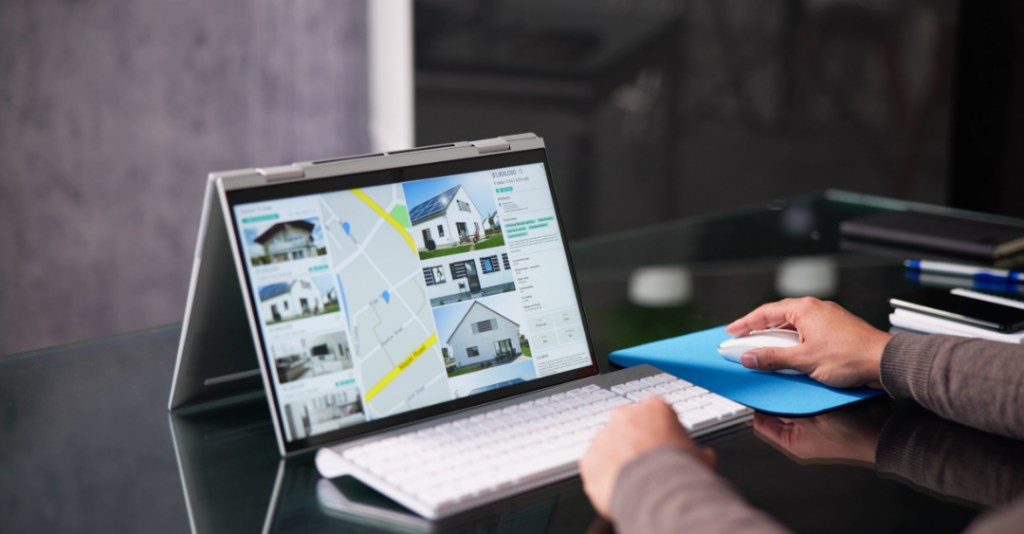 Realtor looking at listings on a computer with multiple houses for sale on it