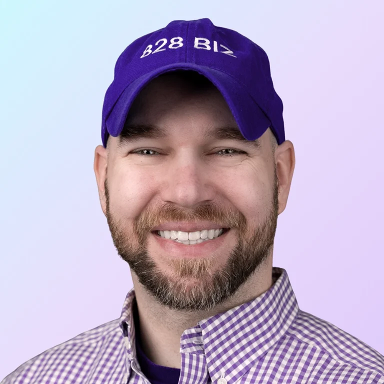 Andrew Murkens, owner of 828 Biz Marketing. Smiling and wearing a purple 828 Biz branded baseball cap and a purple check oxford shirt.