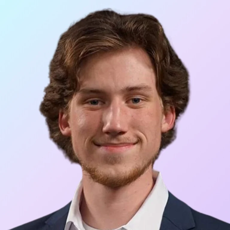 Zach Swekosky, social media marketer at 828 Biz Marketing, smiling and wearing a dark navy blue blazer and white oxford shirt